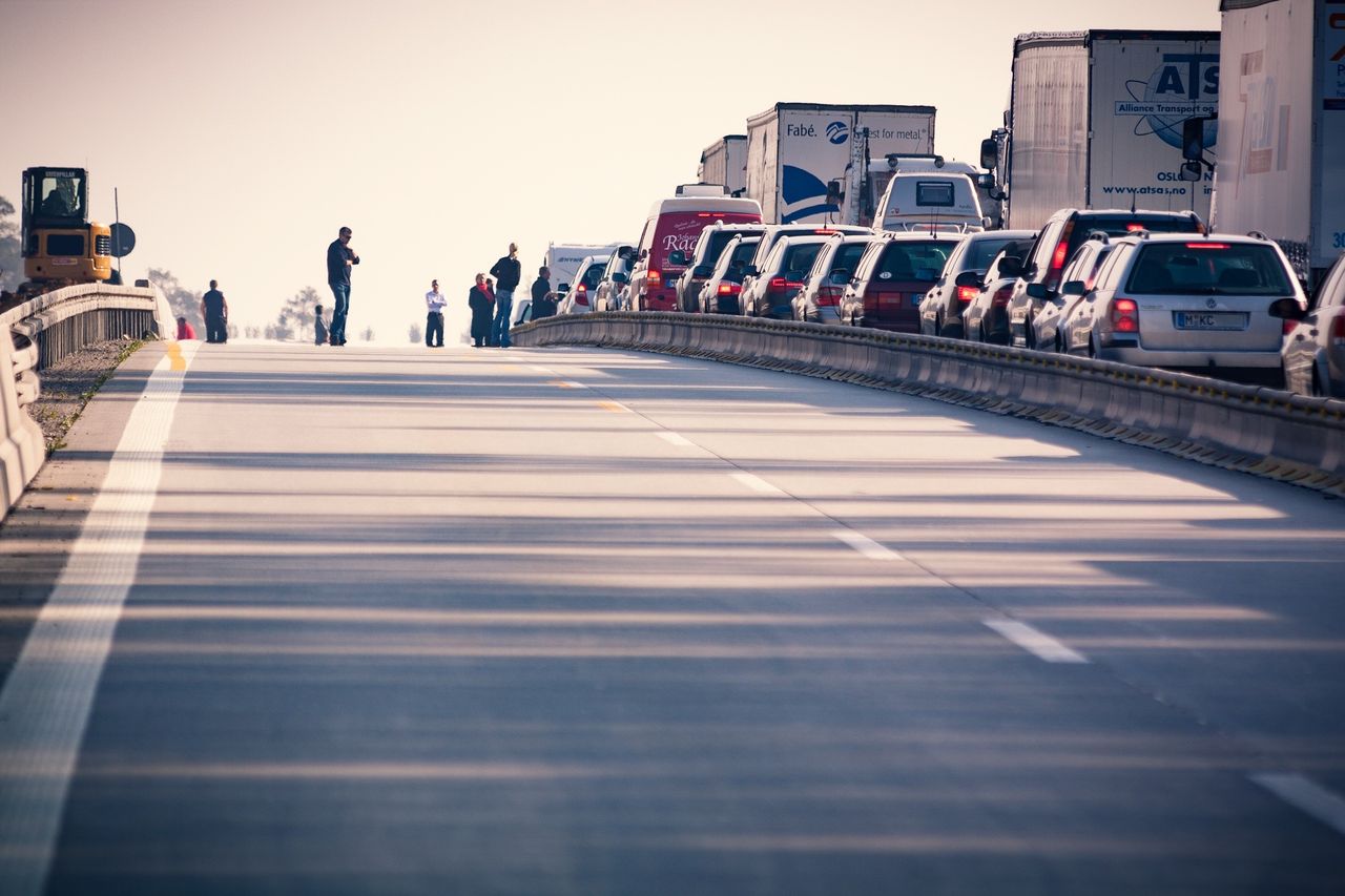 Traffic backed up across several highway lanes while an adjacent lane remains open.