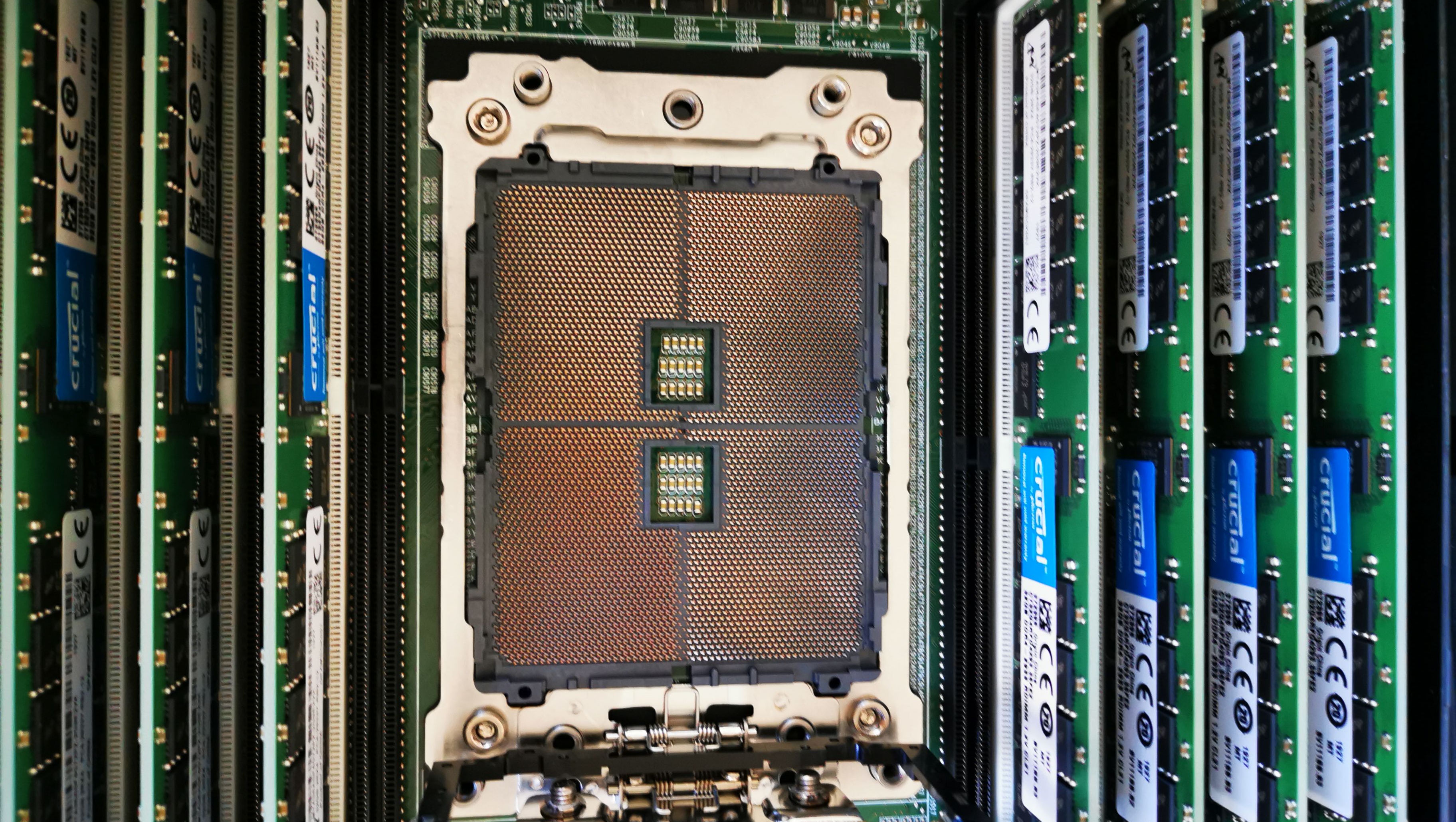 Close-up of a server motherboard with two large processor sockets surrounded by rows of memory modules.